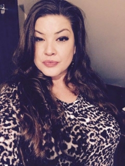 Portrait of woman with long, dark hair, wearing animal-print top