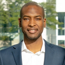 Dwight Best portrait of a man wearing a white shirt with dark blue suit jacket, with a slight smile.
