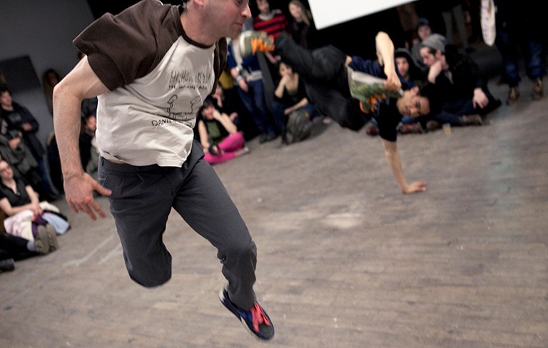 Deux hommes photographiés en train de faire du break-dance.